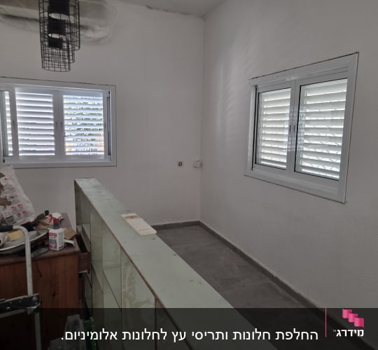 חדר עם חלונות תריסים וכלי עבודה על שולחן